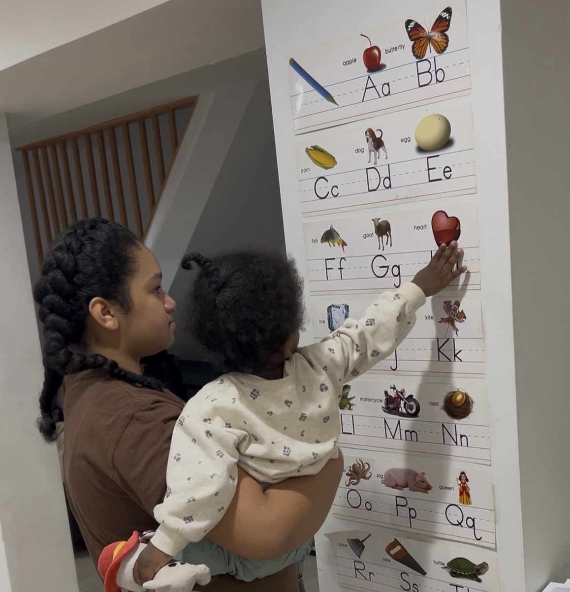 Toddler engaging with an alphabet wall